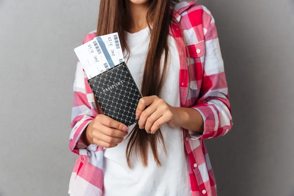 Frau hält Reisepass und Flugtickets in der Hand