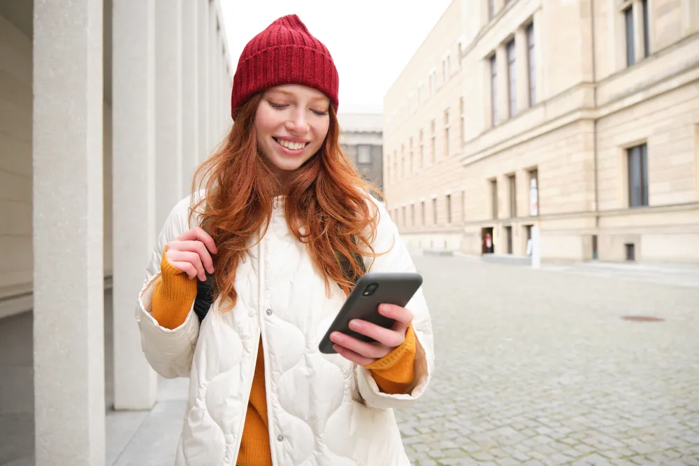 Touristin mit Rucksack nutzt eine Karten-App auf dem Smartphone